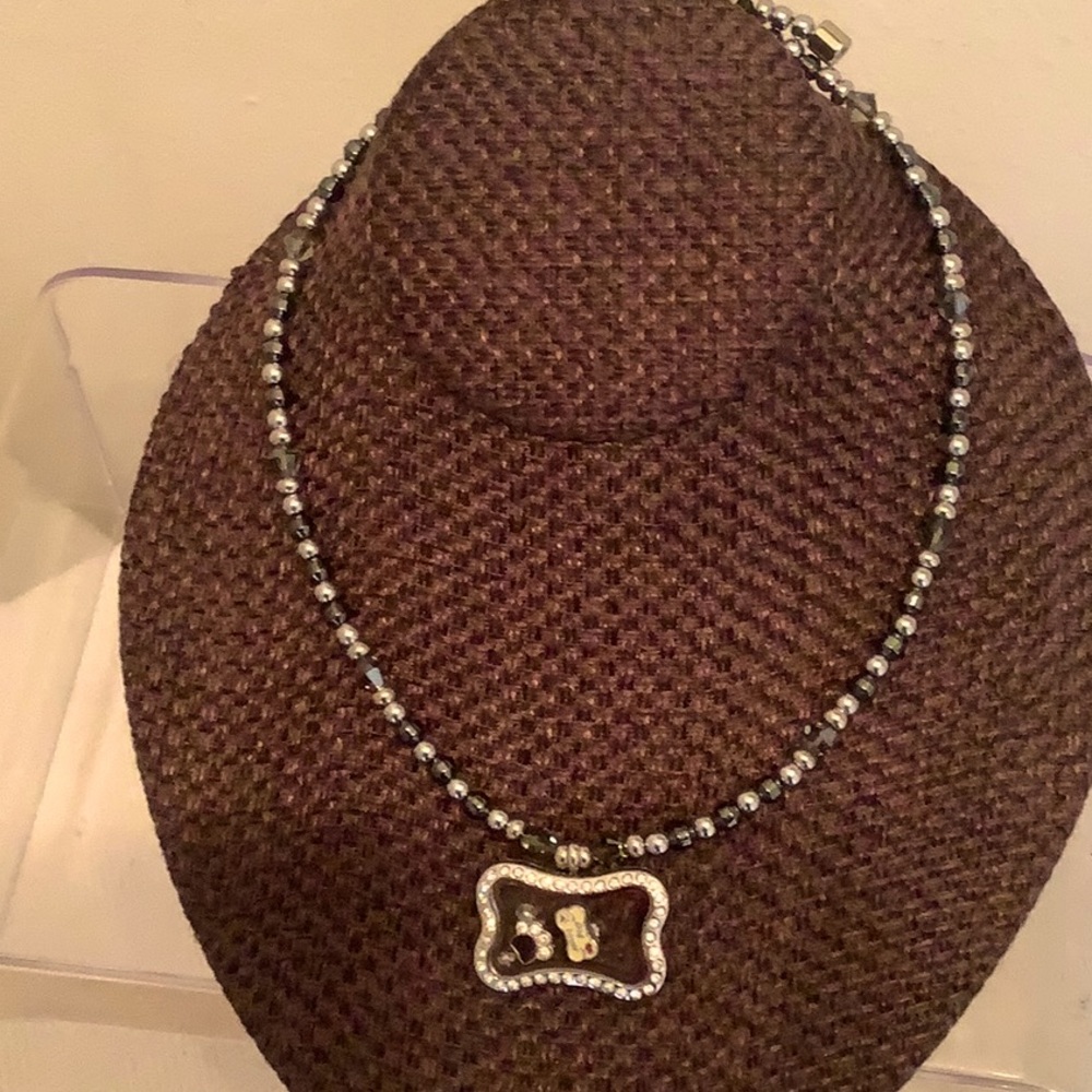 Crystal bone journey locket on hematite magnetic chain. Locket has charms
